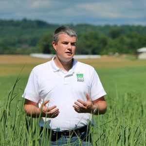 A photo of Sam Jackson standing in a field of switchgrass